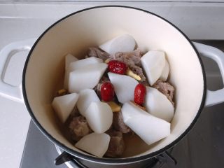 10、冬日温补-萝卜炖排骨,将排骨、萝卜放入炖锅,再放入姜片、红枣和几滴白醋