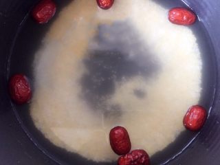 4、小米南瓜红枣粥,淘洗干净的小米、大米倒入电饭煲中,红枣也清洗干净放入,加入适量的清水。