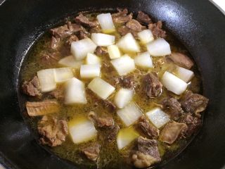 9、牛肉炖萝卜,筷子比较容易可以插入肉块时，放入备用的萝卜块，继续小火煮至萝卜软糯。