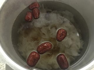 7、桃胶雪燕皂角米银耳羹,把桃胶，银耳捏碎，跟皂角米，红枣一起放入锅里，放上适量的水。开大火烧。