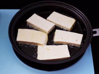 4、香辣煎豆腐,煎锅中加入花生油烧热，再把豆腐依次码放到锅中。