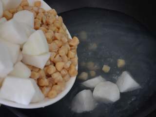 9、干贝玉米萝卜汤,倒入萝卜块和泡发好的干贝。