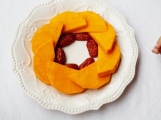 4、美食丨红枣百合蒸南瓜 滋阴润燥美颜,放上南瓜的盘子中间沿着南瓜放入红枣。