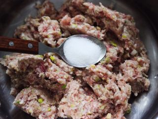 6、香炸猪肉豆腐丸子,加入适量的盐调味,再倒入料酒去除腥味。