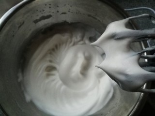 14、红枣酸奶溶豆（新手零失败）,这个时候就要低速打，一是打掉小气泡，二是要慢慢观察打发情况，不能打发过度了。每打20秒就要停下来，轻轻提起打蛋器看下是否出现直钩~打到我图中的状态就OK了（如果操作熟练，连续打估计要5分钟，如果新手，估计要8、9分钟，所以要耐心），盆倒过来蛋白霜都不会流下来。