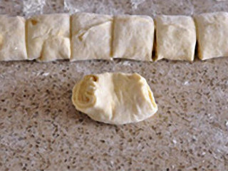 11、油酥烧饼：酥香暖胃治愈系主食,取一份面团略抻长后，捏住收口处，将两端向中间收起。