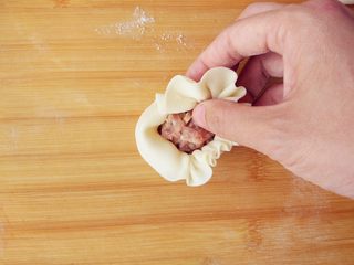 9、烧麦灌香肠土豆丝饼套餐,用勺子将适量馅料放在面片中心，左手托底，在右手捏褶的同时，慢慢转动，且用左手拇指将馅料不断向内压，这样可以包入更多馅料。右手用拇指食指不断将