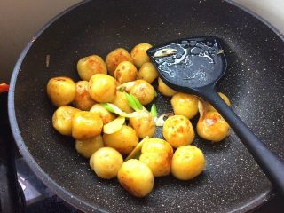 10、烤肉香辣酱煎小土豆,放入葱姜,继续煎