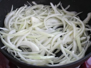 8、洋葱炒肉丝,就锅中底油放入洋葱丝翻炒均匀
