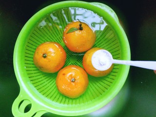 3、糖水桔子,然后放入少许盐，泡10分钟，捞出淋干。