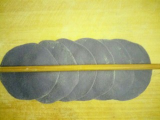9、蓝色妖姬,把每个小剂子揉圆擀成薄片，六个一组错层叠放，用筷子中间压一下