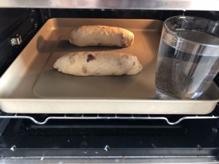 14、红糖红枣桂圆全麦软欧,进行第二次发酵，烤箱内放一杯清水保持适度，如果天气太干可以用小喷壶喷一点水在面团上