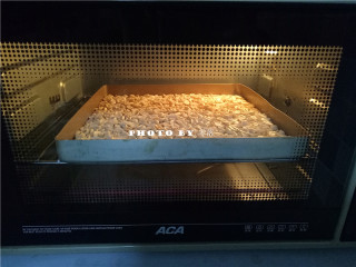 3、椰香牛轧糖,制作牛轧糖时，再将花生倒入烤盘，放入烤箱保温，温度设置为上下火100度，烘烤时间为20分钟；有温度的花生可与棉花糖等材料快速融合；