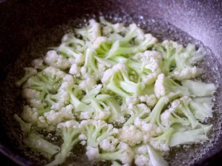 4、绿色美食+酱爆菜花,锅中加入适量水烧开、将菜花洗净焯水