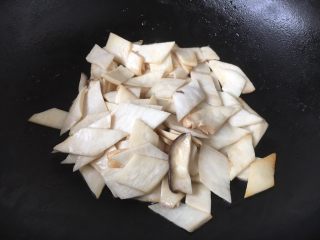 9、#菌类料理# 干锅杏鲍菇,用煸炒五花肉所剩下的底油煸炒杏鲍菇，将杏鲍菇的水分煸炒出去，杏鲍菇软塌下去即可盛出备用。煸炒过的杏鲍菇更容易吸收汤汁，味道会更佳。