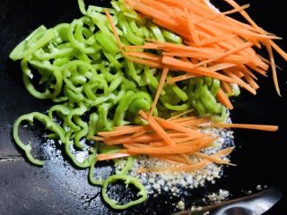 9、青椒炒金针菇,加入胡萝卜和尖椒炒熟。