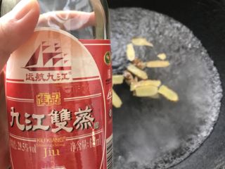3、浓香椰子汤,烧开一锅水,倒入姜片和米酒。