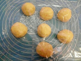 8、胡萝卜小餐包,放案板上按压排气，均匀分成7份，盖保鲜膜松弛15分钟左右