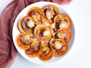 2、蒜蓉辣酱蒸扇贝,食材处理：扇贝可以让市场帮忙处理，拿回来挨个冲洗干净，码在盘子上。