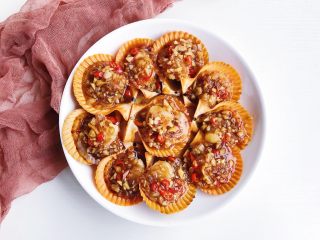 9、蒜蓉辣酱蒸扇贝,将煮好的酱汁均匀的淋在扇贝面上。