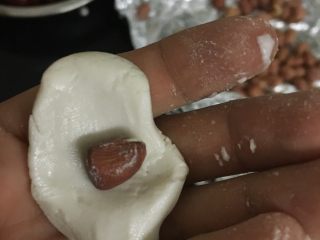 3、心太软（糯米红枣）,取一颗红枣一样大小面团按扁，加入花生米，搓成椭圆形