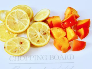 5、水果花茶,柠檬用刀切成薄片，柿子洗净后用刀切小块。