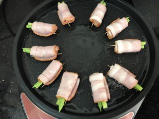 8、芦笋培根卷,把培根卷放入电饼档慢煎