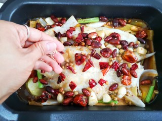 21、家庭版自制烤鱼,将炒好的花生，黄豆，蒜瓣，干辣椒一起撒在鱼上，并撒上适量的芝麻提香。