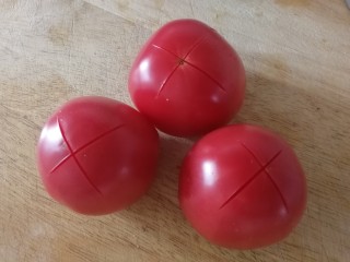 4、番茄烧冬瓜,柿子顶部切十字花刀，开水里烫半分钟。