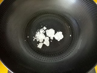 7、#山楂球#,把冰糖碎块放入锅中。开火。用中火熬开。