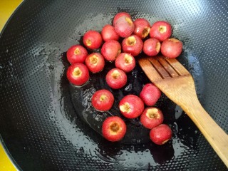 11、#山楂球#,看到冒白泡，水分烤干时，放入山楂，立即关火。用铲子快速搅拌，使山楂表面均匀被糖汁包裹，继续搅拌，随着温度变低，糖汁也变成白色的结晶。