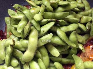 7、卤毛豆,倒入毛豆翻炒一分钟左右，使其均匀地裹上红油豆瓣～