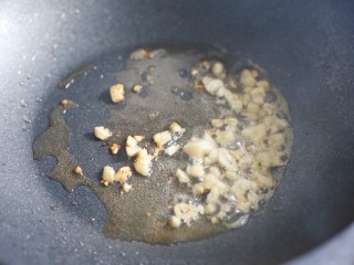 6、简单好吃的炒四季豆,热锅热油加大蒜爆香。