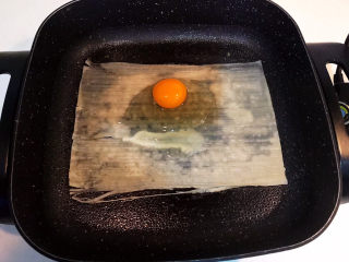 9、冬至美食  正宗东北烤冷面,在冷面四周撒一点冷水，免得冷面四边翘起来，在冷面上打入一颗鸡蛋