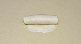 8、栗子酥,将做好的面团按压擀开成椭圆形，底部压薄自上而下卷起，放置在一边，依次做好全部盖保鲜膜松驰10分钟。