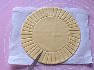 6、吉祥枣花馍,拿个圆形模具，在圆饼的中央位置轻轻压个印，再用刀在面饼的周围切出长宽一致的条。