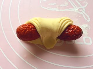 12、吉祥枣花馍,如图：把尖角拉过来，用食指按压紧。