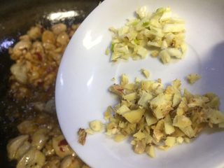 10、泡椒莴笋炒嫩鸡丁,放入大蒜老姜末,此步需把豆瓣炒出红油色飘香