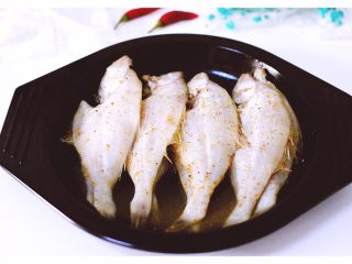 8、#咸味#酥炸片口鱼,倒入料酒把片口鱼抓匀后腌制20分钟左右