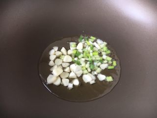 6、蒜蓉苋菜,热锅凉油,放入蒜片和葱花,煸炒出香味。