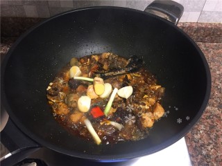 6、红烧跑山鸡,放入葱头、大蒜、生姜和八角翻炒片刻。