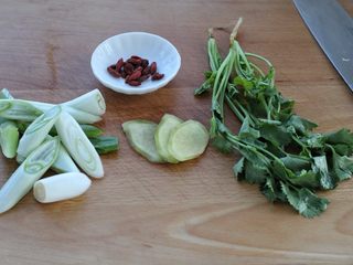 2、清炖牛肉萝卜汤,准备辅料:大葱切小段,生姜切片状,枸杞和香菜洗净备用
