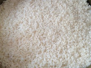 5、糯米大晶糕,将糯米均匀的铺在粽叶上，按压片刻