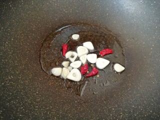 7、西兰花红萝卜烩鸡肉,锅内重新倒油烧热，下入蒜片和干红辣椒炒香。