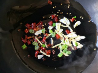 5、十味 香辣小鱼干,锅中适量的油烧热后下入葱姜蒜和一半的干辣椒花椒爆出香味。