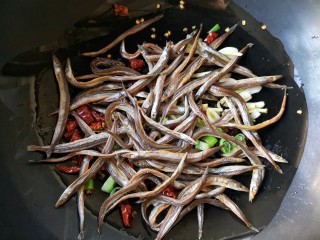 6、十味 香辣小鱼干,下入小鱼干小火翻炒。（另一种方法是锅中宽油烧至5成热，下小鱼干炸2-3分钟，沥油捞出后再放入锅中和干辣椒葱姜蒜等一起煸炒，这种方法摄入油量会有点多，大家可以根据个人需要自行选择烹饪方法。）