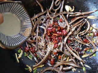 9、十味 香辣小鱼干,再加入剩下一半的得干辣椒和白芝麻翻炒均匀。