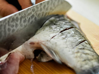 2、烤鱼,清洗干净后，在鱼身上划几刀。