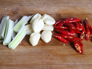 3、子姜鸡,小米辣椒、大葱切段破开，大蒜去皮拍碎备用。