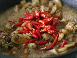 13、子姜鸡,下入切好的小米椒，待锅中汤汁减少收汁即可。